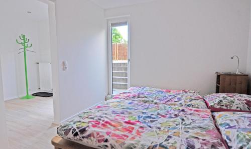 a bedroom with a bed with a colorful comforter at Ferienwohnung Nöthen in Kottenheim