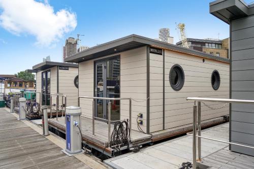 a small building on a dock in a city at Unique Water Lodge in London - Sleeps 6 in London