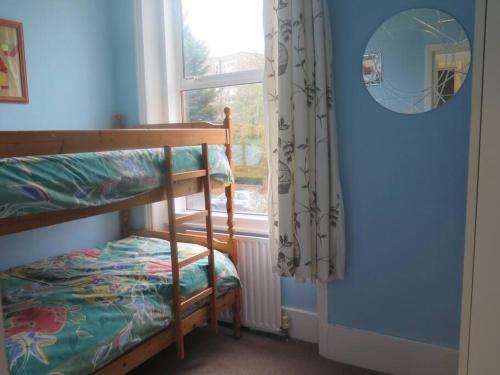 a bedroom with a bunk bed and a window at Kent Gardens Apartment in Perivale