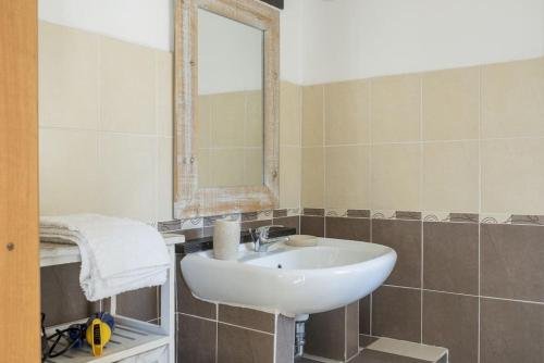 a bathroom with a white sink and a mirror at Al Khalisa Bright and cozy apt at Magione in Palermo