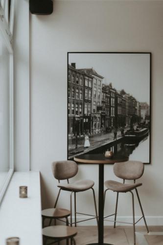 a table with two chairs and a picture on the wall at Boutique Hotel First City in The Hague