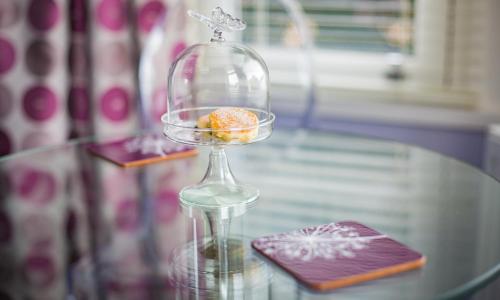 a glass container with a donut in it on a glass table at Studios At Glenthorne in Merthyr Tydfil