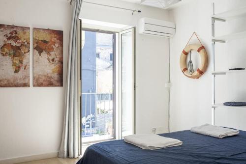 a bedroom with a bed and a large window at Al Khalisa Bright and cozy apt at Magione in Palermo