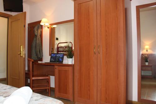 a bedroom with a desk and a bed with a laptop at Hotel Jole in Cesenatico