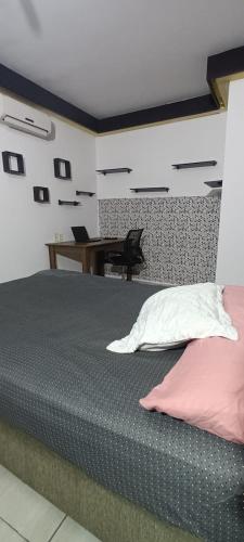 um quarto com uma cama e uma secretária com um computador portátil em republica madagascar em Florianópolis