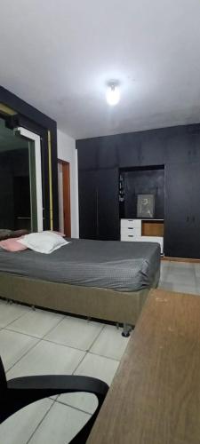 a bedroom with a bed and a black wall at republica madagascar in Florianópolis