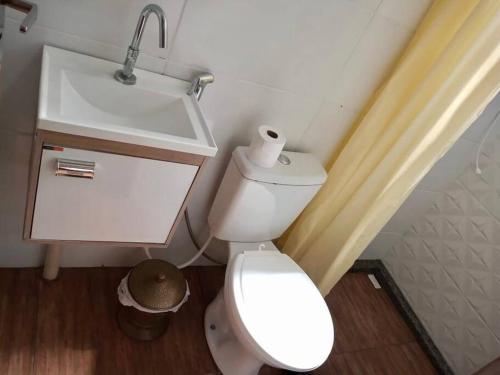 a bathroom with a white toilet and a sink at Casa Container com piscina. Sem a tenda da frente in Bonito