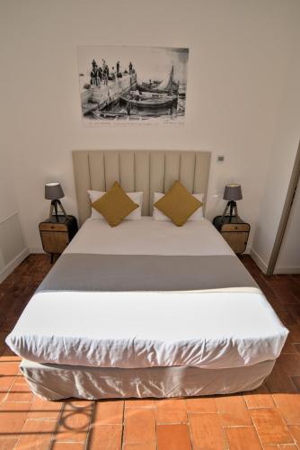 a bedroom with a large white bed with two lamps at Hôtel Casa Rossa & Spa in LʼÎle-Rousse