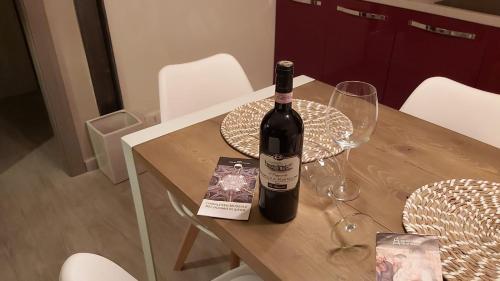 a bottle of wine sitting on top of a wooden table at La Limonaia Country House in Monteriggioni