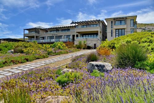 a building with a garden with purple flowers at The Shark Bay Boutique Hotel & Spa in Langebaan