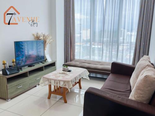 ein Wohnzimmer mit einem Sofa, einem TV und einem Tisch in der Unterkunft 7th Avenue Stay (Sutera Avenue) in Kota Kinabalu