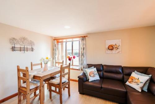 a living room with a couch and a table at The Stable at Clauchan Holiday Cottages in Gatehouse of Fleet