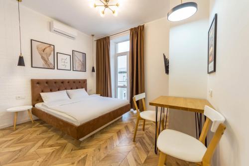 sypialnia z łóżkiem, stołem i krzesłami w obiekcie Idea Design Apart-Hotel Chykalenka w Kijowie
