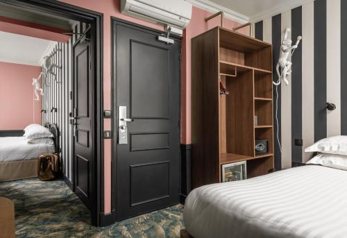 1 dormitorio con 2 camas y puerta negra en Hotel Archetype Etoile, en París