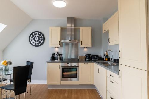 a kitchen with white cabinets and a stove top oven at Cotels The Millhouse Corporate Apartments - PRIVATE APARTMENT BUILDINGS - GATED ENTRANCE - PARKING - WORK DESK in Derby