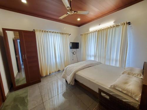 a bedroom with a bed and a ceiling fan at zoz Vagamon in Vagamon