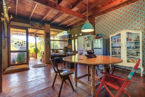 a dining room with a wooden table and chairs at In The Green Backpackers in Morganʼs Bay