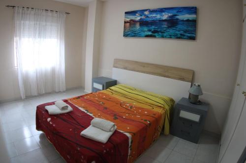 sypialnia z łóżkiem z dwoma ręcznikami w obiekcie Apartamentos Marina Internacional w mieście Torrevieja