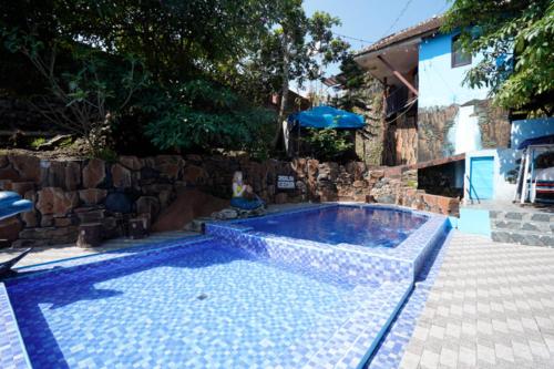 a swimming pool in a yard with a stone wall at OYO 927 Carina Hotel in Mojokerto