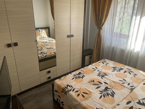 a bedroom with a bed and a dresser at Bucuresti Comfort Apartment in Bucharest