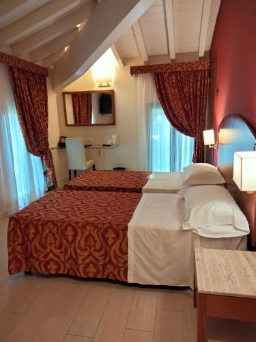 a hotel room with a large bed and windows at Savoia Hotel Country House Bologna in Bologna
