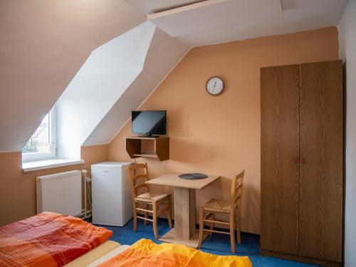 1 dormitorio con 1 cama y 1 mesa con TV en Hotel Club, en Vranovská Ves