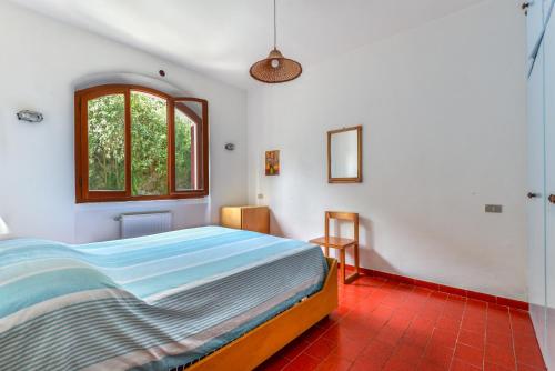 Schlafzimmer mit einem Bett und einem Fenster in der Unterkunft Casa Cerboli in Cavo
