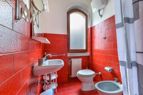 een rode badkamer met een wastafel en een toilet bij Casa Cerboli in Cavo