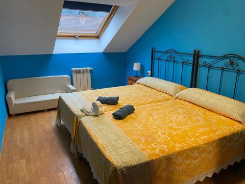 1 dormitorio con 1 cama grande con manta amarilla en Los beyos, en Cangas de Onís