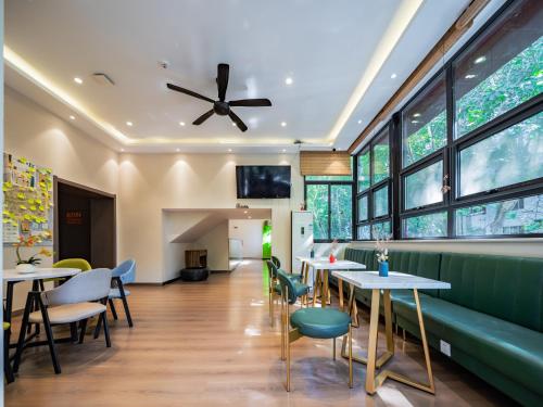 een restaurant met tafels, stoelen en ramen bij Wutong ins Designer Hotel in Xi'an