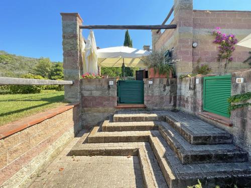 una casa con puertas verdes y escaleras en un patio en Sant'Anna del Volterraio - Margherite 5, en Bagnaia