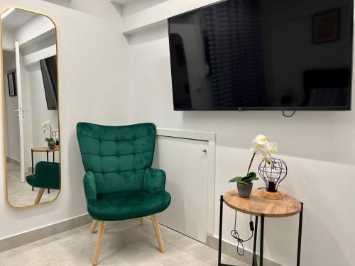 uma cadeira verde numa sala de estar com um espelho em Attiki Apartment vipgreece em Atenas
