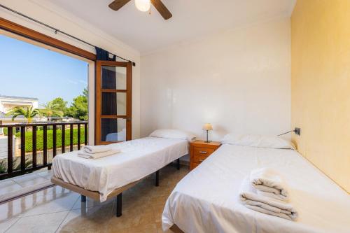 Dos camas en una habitación con balcón. en Villa Can Tosam Meiga, en Calas de Mallorca
