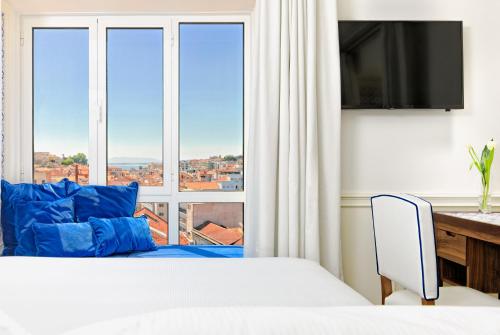 a bedroom with a bed and a large window at H10 Duque de Loule in Lisbon