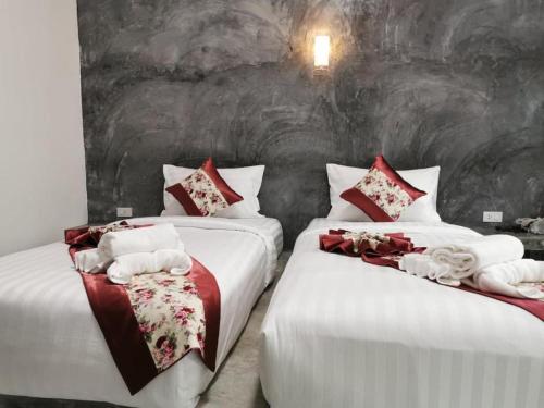a bedroom with two beds with red and white sheets at Lanta Long Beach Hostel in Ko Lanta