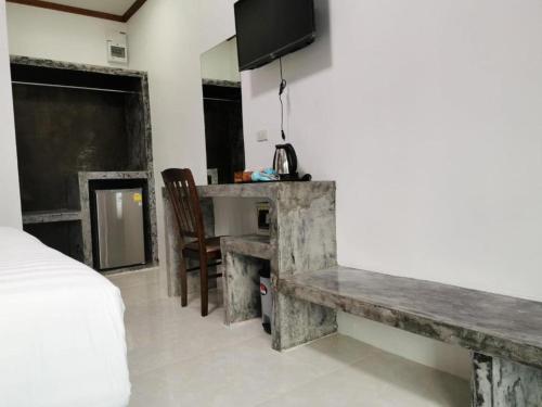 een kamer met een bed, een tafel en een televisie bij Lanta Long Beach Hostel in Koh Lanta