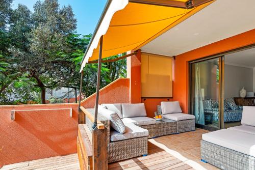 um pátio exterior com dois sofás e um guarda-chuva em MEDANO4YOU Garden Xu em La Tejita