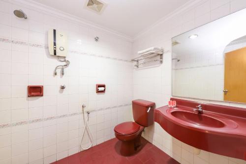 La salle de bains est pourvue de toilettes rouges et d'un lavabo. dans l'établissement Super OYO 473 Comfort Hotel 2, à Klang