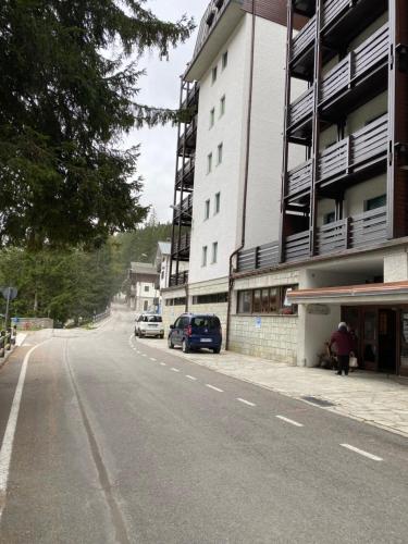 an empty street with cars parked next to a building at Suite Neve in Madesimo