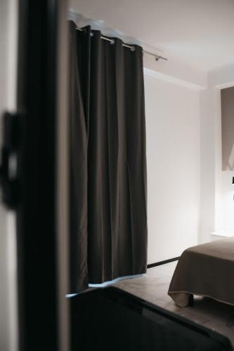 a black curtain in a room with a bed at Greta Apartments in Taranto