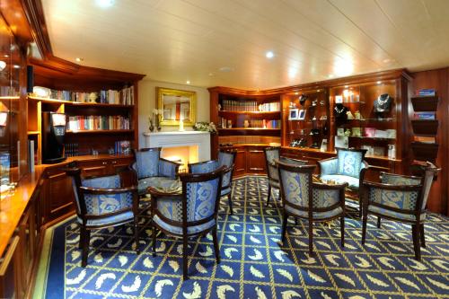 una biblioteca en un crucero con sillas y libros en Hotelschiff Messe Düsseldorf en Düsseldorf