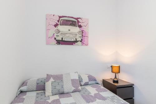 um quarto com uma cama e uma fotografia de um carro na parede em Esperanza em Polop