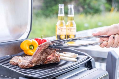 a steak on a grill with two bottles of beer at Nanki Shirahama Angel in Shirahama