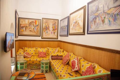 un soggiorno con divano giallo e cuscini rossi di Dar Mounia a Rabat