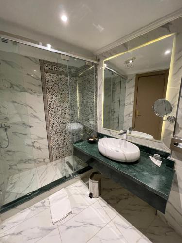 a bathroom with a sink and a large mirror at Menzeh Zalagh 2Boutique Hôtel & Sky in Fès