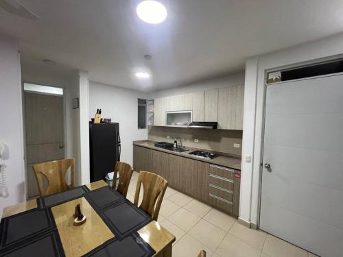 Hermoso apartamento para descansar en familia في جيراردو: مطبخ مع طاولة وكراسي وثلاجة