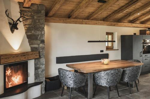 a dining room with a fireplace and a wooden table at Chalet Ruhpolding Bayern in Ruhpolding