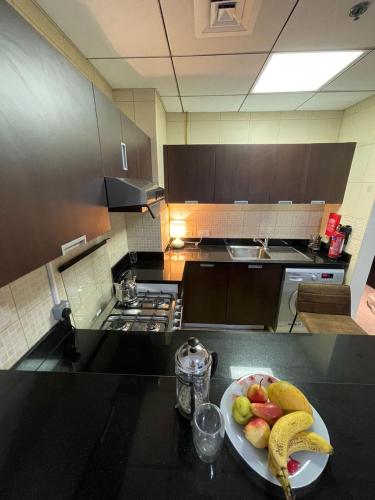 a plate of fruit on a counter in a kitchen at Big studio, Dubai SportCity, parking included in Dubai