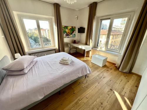 a bedroom with a bed and two large windows at Tricolore Suite in Milan