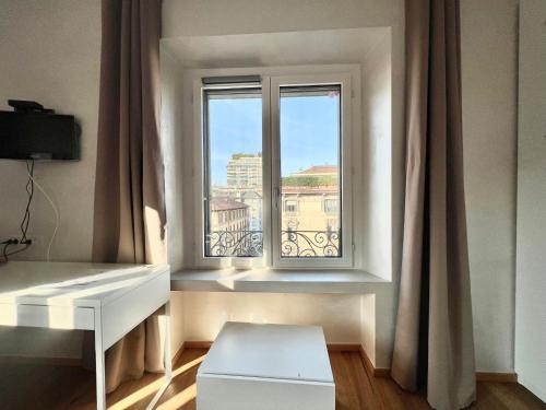 a room with a window with a white desk at Tricolore Suite in Milan
